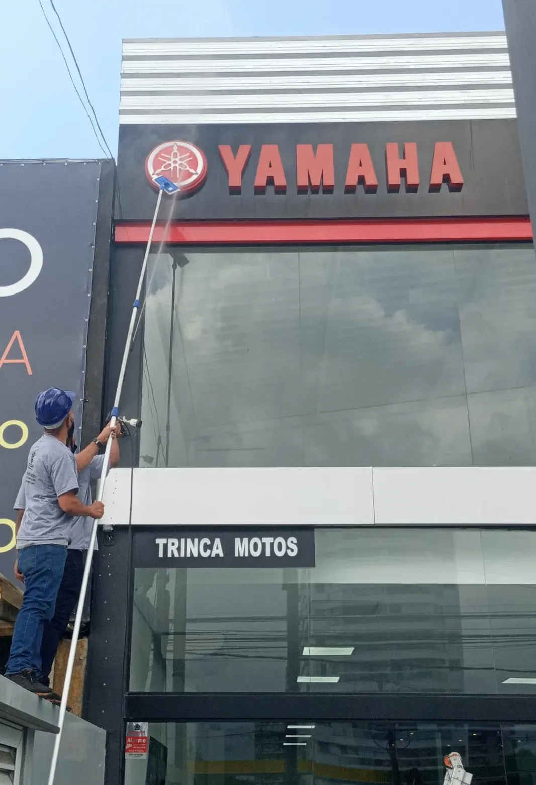 Profissional limpando porta de vidro com rodo